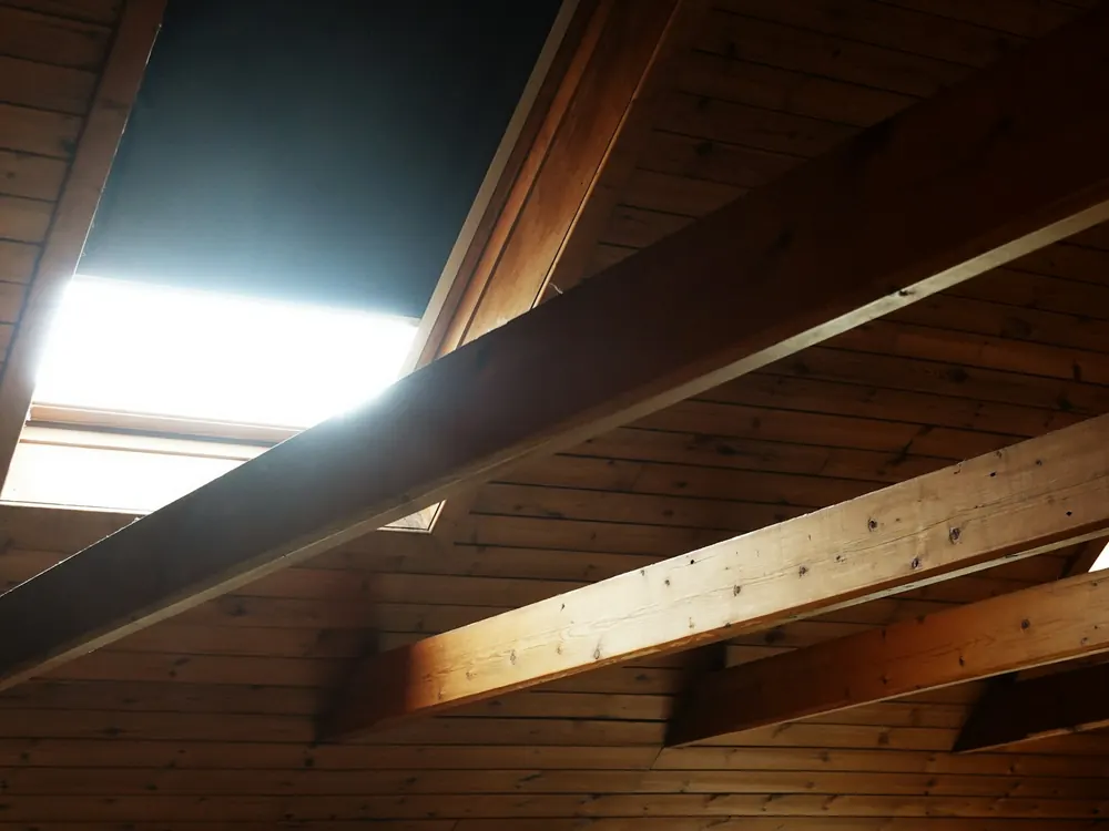 Nahaufnahme von Deckenbalken und Dachsparren mit den Hohlräumen dazwischen
