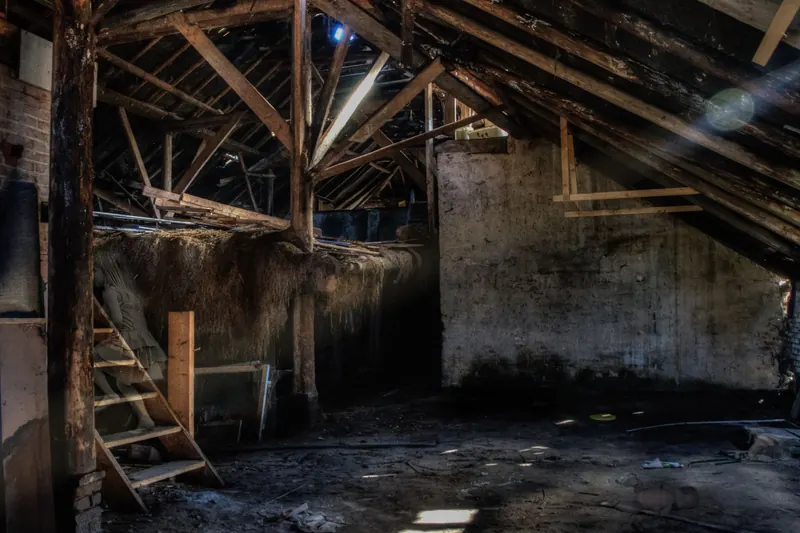 Alter Dachboden mit freiliegenden Holzbalken und verputzten Zwischenwänden